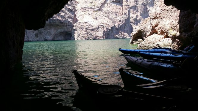 Multiple blue colored boats in a sea cave